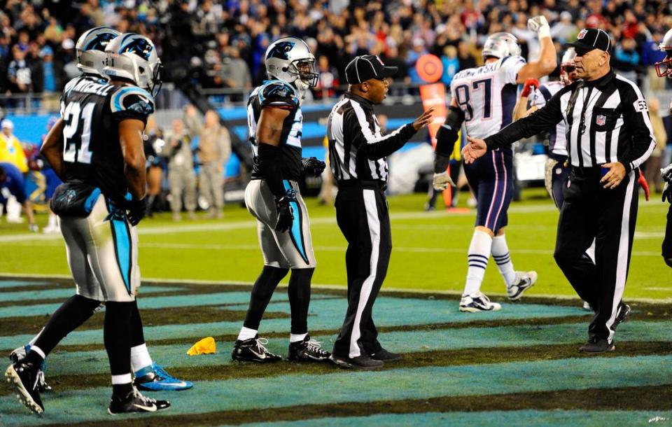 NFL back judge Terrence Miles (111) (center) talks with umpire Garth DeFelice (53) after Miles threw a flag for pass interference on the last play in the Carolina Panthers-New England Patriots game at Bank of America Stadium on November 18, 2013. The flag was ultimately waved off, as Tom Brady’s intercepted pass was deemed to have been uncatchable by tight end Rob Gronkowski (87). The Panthers won, 24-20. DAVID T. FOSTER III/dtfoster@charlotteobserver.com