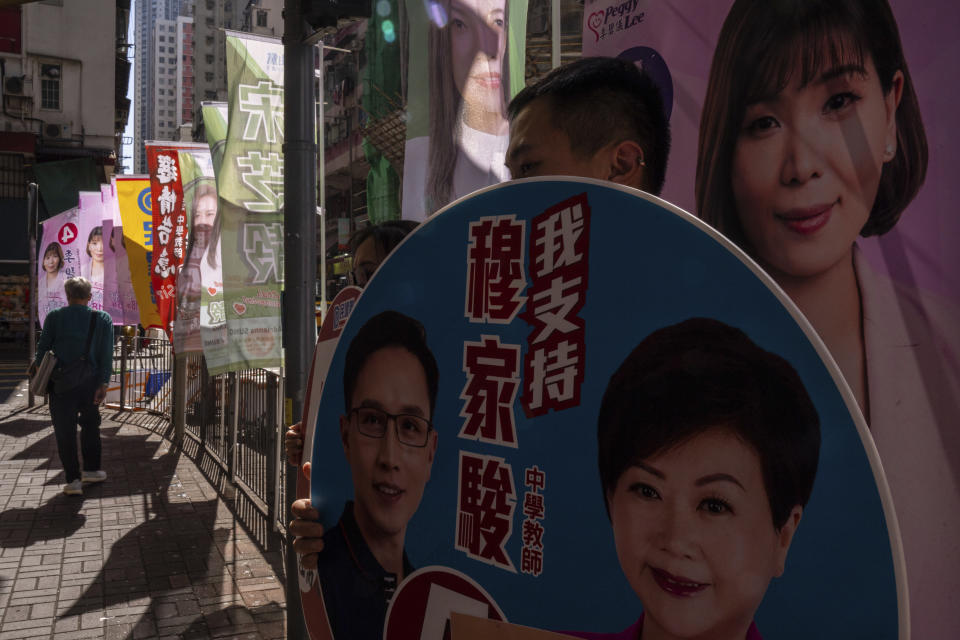 Campaigners promote candidates during the District Council elections in Hong Kong, Sunday, Dec. 10, 2023. Residents went to the polls on Sunday in Hong Kong's first district council elections since an electoral overhaul was implemented under Beijing's guidance of “patriots” administering the city, effectively shutting out all pro-democracy candidates. (AP Photo/Louise Delmotte)