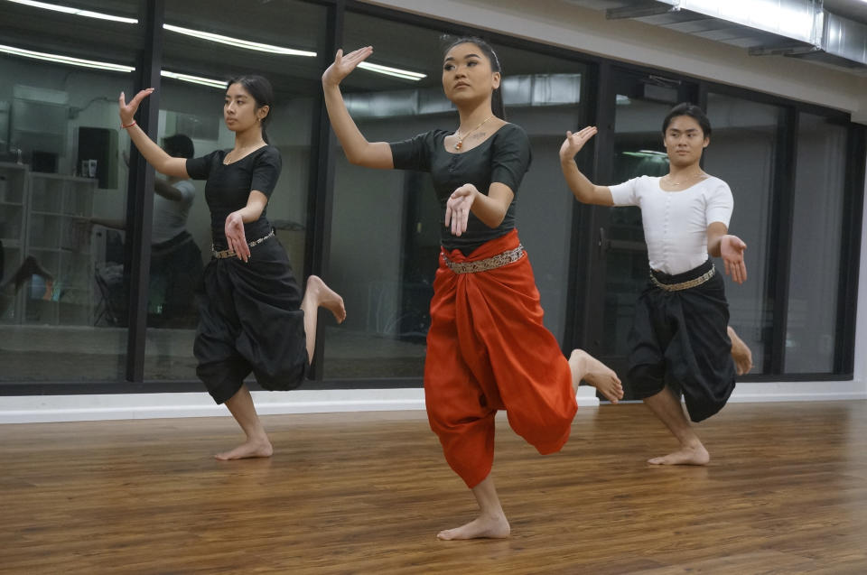 From left, Gabriella Sour, Sabrina Sok and Garrett Sour rehearse traditional, sacred Cambodian dances in the Wattanak Dance Troupe studio on Friday, Feb. 3, 2023, in Minneapolis. Seeking to keep ties to both Buddhism and ancestral culture vibrant for new generations, the troupe, which started in the Buddhist temple of Watt Munisotaram, issued its first open enrollment call this winter. (AP Photo/Giovanna Dell'Orto)