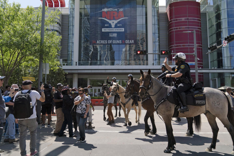 Mounted police officers tell protesters to move back across the street from the National Rifle Association annual meeting at the George R. Brown Convention Center in Houston, Friday, May 27, 2022. (AP Photo/Jae C. Hong)