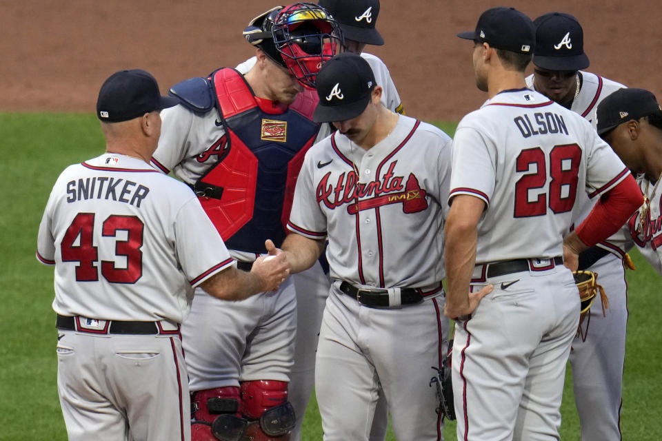 Atlanta Braves starting pitcher Spencer Strider, center, hands the ball to manager Brian Snitker (43) after being pulled during the third inning of a baseball game against the Pittsburgh Pirates in Pittsburgh, Monday, Aug. 7, 2023. (AP Photo/Gene J. Puskar)