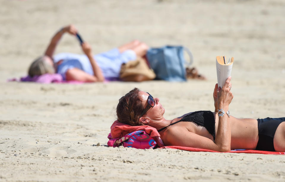 WEYMOUTH, ENGLAND - JUNE 24: Visitors enjoy the hot weather on the beach on June 24, 2020 in Weymouth, United Kingdom. The UK is experiencing a summer heatwave, with temperatures in many parts of the country expected to rise above 30C and weather warnings in place for thunderstorms at the end of the week. (Photo by Finnbarr Webster/Getty Images)