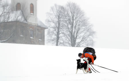 A man kisses his dog during a stage of the Sedivackuv Long dog sled race in Destne v Orlickych horach, Czech Republic, January 25, 2019. REUTERS/David W Cerny