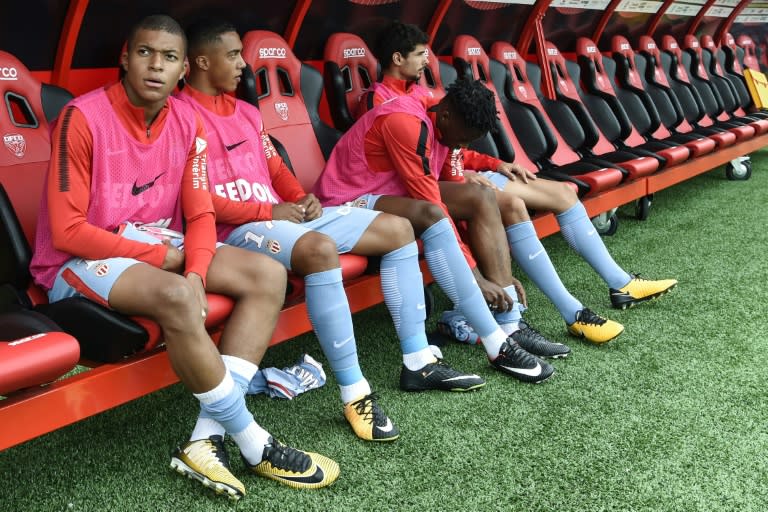 Monaco's forward Kylian Mbappe (L) sits on the bench during the French Ligue 1 football match against Dijon FCO August 13, 2017