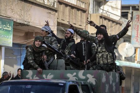 Fighters of the Kurdish People's Protection Units (YPG) carry their weapons along a street in the Syrian Kurdish city of Qamishli, in celebration after it was reported that Kurdish forces took control of the Syrian town of Tel Hamis, February 27, 2015. REUTERS/Rodi Said