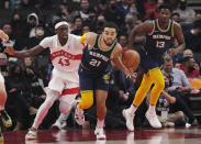 Memphis Grizzlies guard Tyus Jones (21) looks up court in front of Toronto Raptors forward Pascal Siakam (43) and Grizzlies forward Jaren Jackson Jr. (13) during the first half of an NBA basketball game Tuesday, Nov. 30, 2021, in Toronto. (Nathan Denette/The Canadian Press via AP)