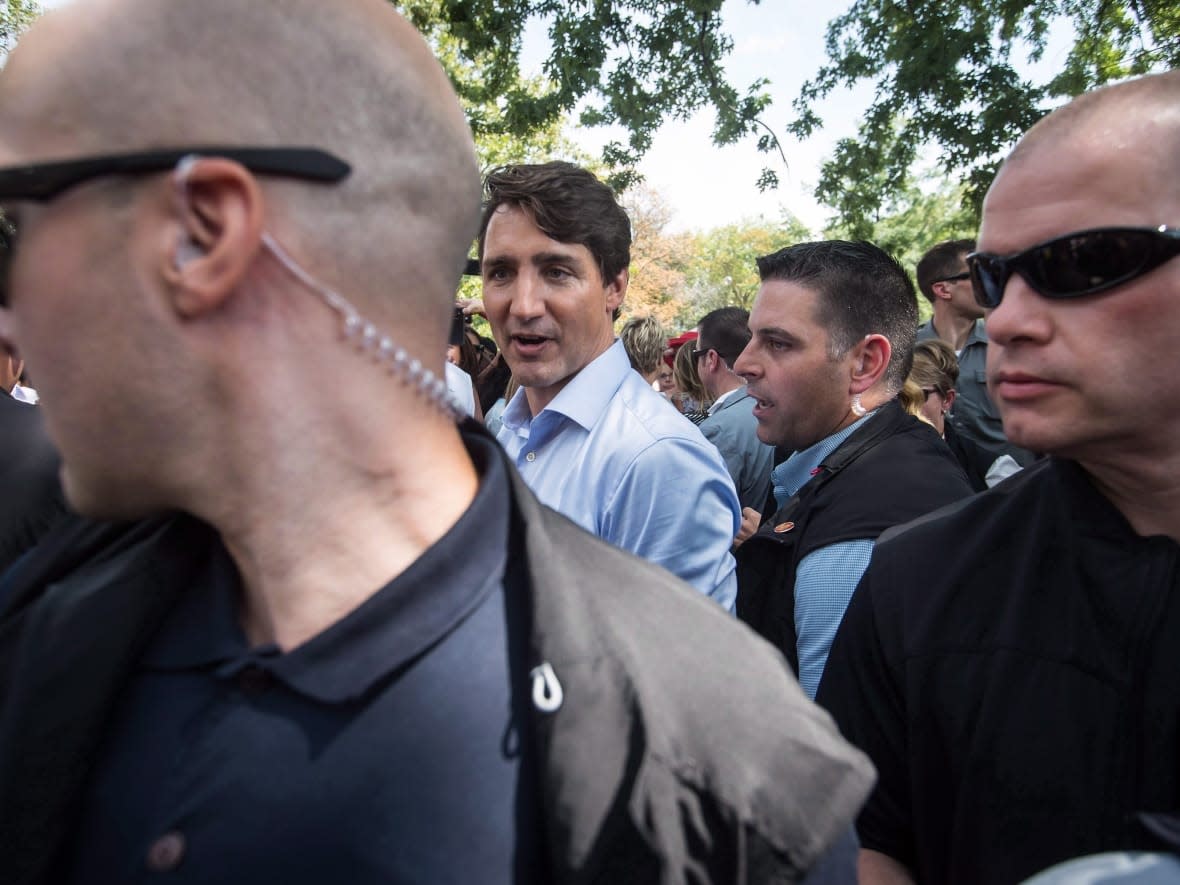 Prime Minister Justin Trudeau, back left, is surrounded by his security detail as he greets people during a visit to B.C. Day celebrations in Penticton, B.C., on Monday August 6, 2018. (The Canadian Press/Darryl Dyck - image credit)