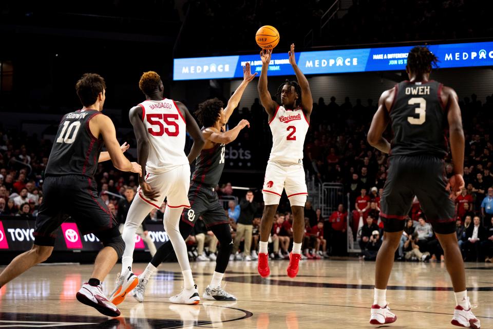 Cincinnati Bearcats guard Jizzle James (2) hits a 3-point basket as Oklahoma Sooners guard Milos Uzan (12) guards him in the second half of the NCAA basketball game between Cincinnati Bearcats and Oklahoma Sooners at Fifth Third Arena in Cincinnati on Saturday, Jan. 20, 2024.