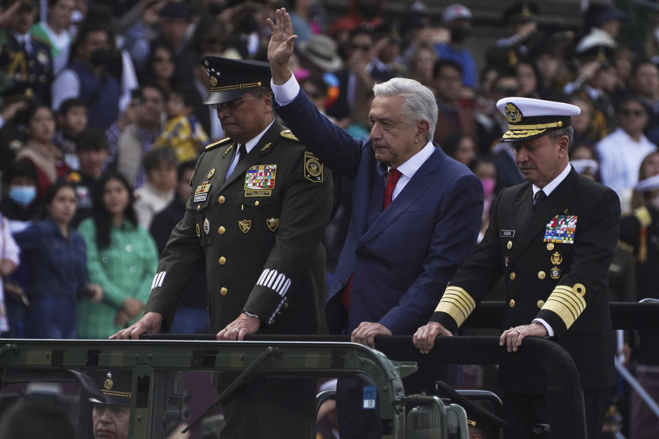 Mexican President Andres Manuel Lopez Obrador waves alongside Defense Secretary Luis Crescencio Sandoval, left, and Navy Secretary Vidal Francisco Soberon as they ride through the Zocalo during the Independence Day military parade in Mexico City, Friday, Sept. 16, 2022. (AP Photo/Marco Ugarte)