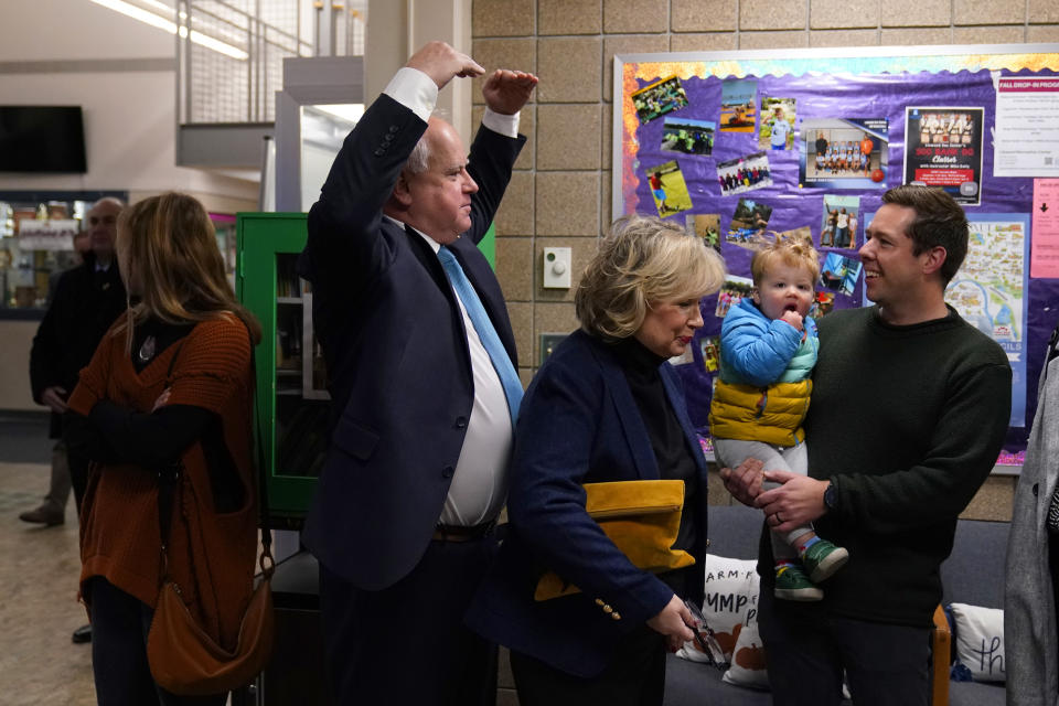 Minnesota Gov. Tim Walz, middle, interacts with voters while waiting in line to vote Tuesday, Nov. 8, 2022, in St. Paul. (AP Photo/Abbie Parr)