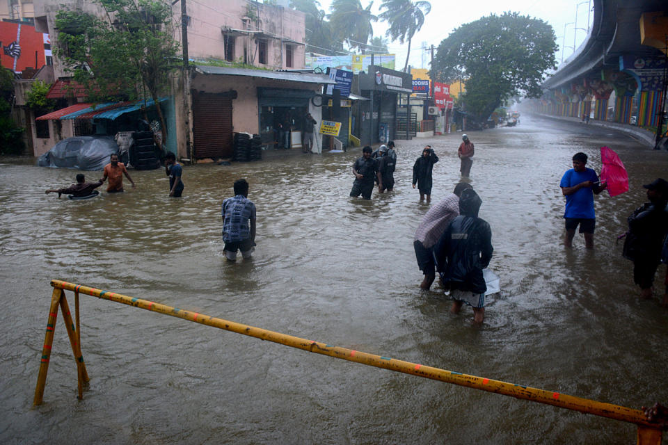 People wade through a flooded street following heavy rains along the Bay of Bengal coast in Chennai, India, Monday, Dec.4, 2023. Authorities issued warnings for tropical storm Michuang, which is likely to hit the southern coast on Tuesday with maximum sustained winds of 90-100 kilometers (56-62 miles) per hour with gusts up to 110 kph (68 mph), the Indian Meteorological Department said. (AP Photo)