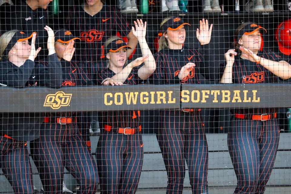 Oklahoma State players cheer from the dugout during Saturday's game against Baylor at Cowgirl Stadium in Stillwater.