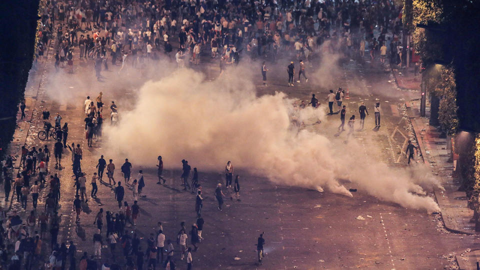 Police throwing teargas at people rioting after celebrations of the Russia 2018 World Cup final on the Champs-Elysees avenue in Paris. Pic: Getty