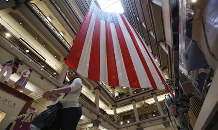 A shopper walks past a giant U.S. flag on display, ahead of the Memorial Day holiday, in a department store in Chicago, Illinois, May 23, 2014. REUTERS/Jim Young