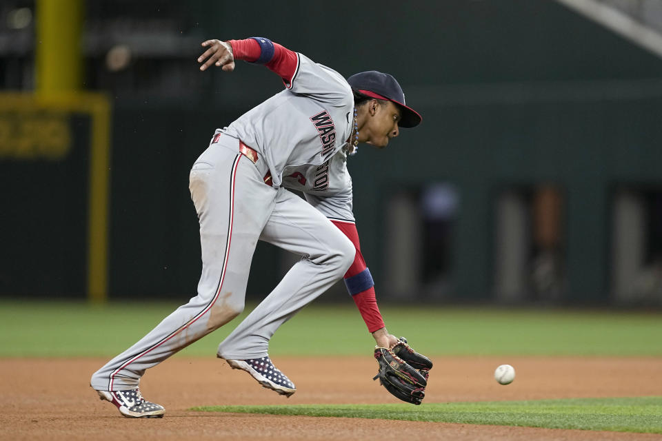 Washington Nationals shortstop CJ Abrams reaches down to field a single hit by Texas Rangers' Nathaniel Lowe in the fourth inning of a baseball game in Arlington, Texas, Tuesday, April 30, 2024. (AP Photo/Tony Gutierrez)