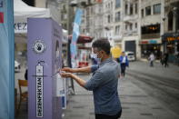 A man, wearing a protective mask against the spread of coronavirus, uses disinfectant from a public station on Istiklal street, the main shopping street in Istanbul, Thursday, June 18, 2020. Turkish authorities have made the wearing of masks mandatory in Istanbul, Ankara and Bursa to curb the spread of COVID-19 following an uptick in confirmed cases since the reopening of many businesses. (AP Photo/Emrah Gurel)