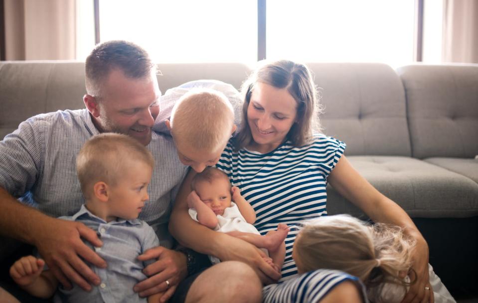 two parents snuggle with four young kids