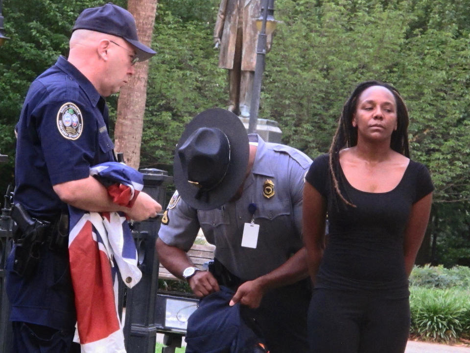 Bree Newsome of Charlotte, N.C., right, is taken into custody after she removed the Confederate battle flag from a monument in front of the South Carolina Statehouse in Columbia, S.C., on Saturday, June, 27, 2015. 