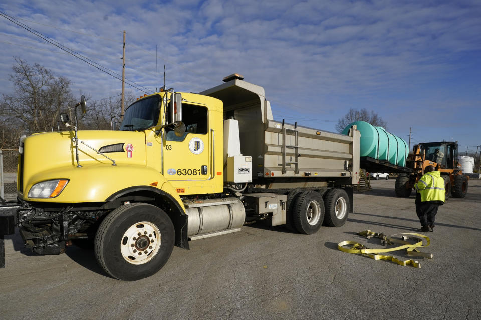 Indiana Department of Transportation employees prepare a snow plow truck, Tuesday, Dec. 20, 2022, in Indianapolis. A large swath of the U.S. is bracing for a potentially deadly weather trifecta — dangerously cold temperatures, howling winds and a significant winter storm. Bitter cold and heavy snow are descending over the Plains and upper Midwest. (AP Photo/Darron Cummings)