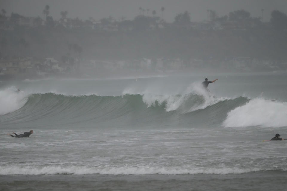 Surfers ride waves off Doheny State Park Beach in Dana Point, Calif., Sunday, Aug. 20, 2023. Tropical Storm Hilary swirled northward Sunday just off the coast of Mexico's Baja California peninsula, no longer a hurricane but still carrying so much rain that forecasters said "catastrophic and life-threatening" flooding is likely across a broad region of the southwestern U.S. (AP Photo/Damian Dovarganes)