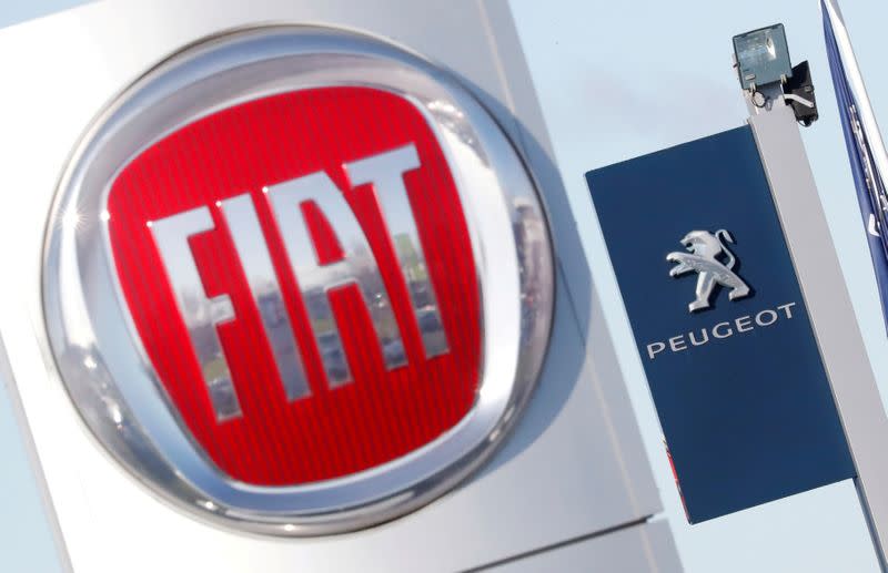 FILE PHOTO: The logos of car manufacturers Fiat and Peugeot are seen in front of dealerships of the companies in Saint-Nazaire