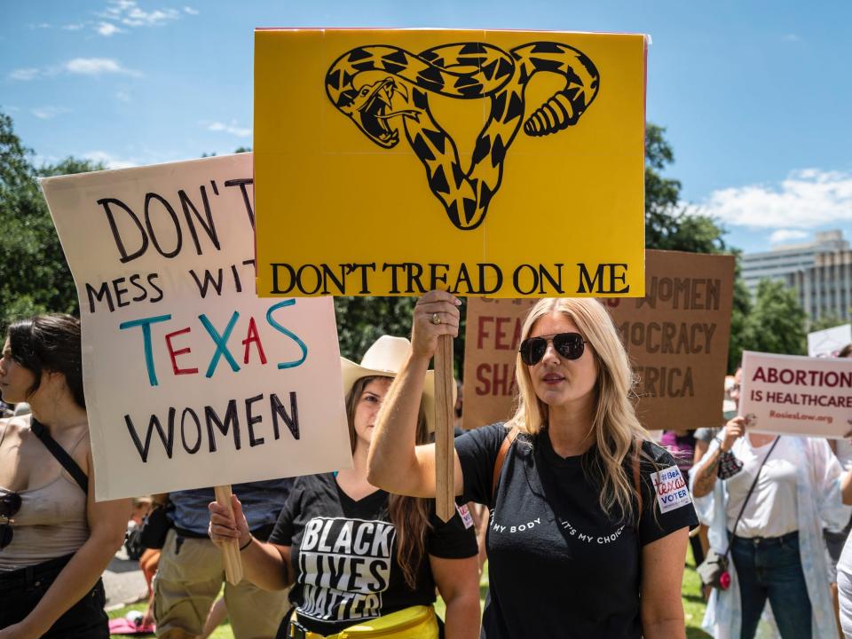 Protesters hold up signs at a protest against Texas' new abortion law outside the state capitol on May 29, 2021 in Austin, Texas.