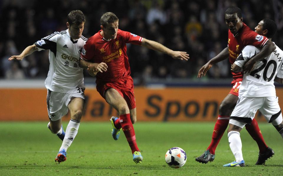 Swansea City's Ben Davies (L) challenges Liverpool's Jordan Henderson (2nd L) as Swansea City's Jonathan De Guzman (R) gets into a tussle with Liverpool's Andre Wisdom during their English Premier League soccer match at the Liberty Stadium in Swansea, Wales September 16, 2013.