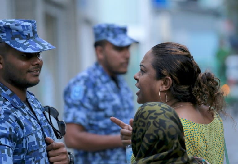 A Maldivian opposition activist argues with a policeman outside parliament on March 27, 2017