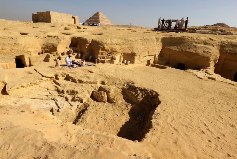 An Egyptian archaeologist restores antiquities after the announcement of new discoveries in Gisr el-Mudir, in Giza