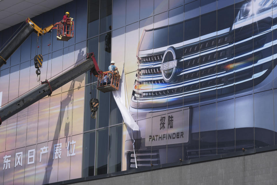 Workers prepare for the upcoming auto show to be held in Beijing, China, Wednesday, April 24, 2024. Foreign automakers have been caught flat-footed in China by an electric vehicle boom that has shaken up the market over the last three years. That has left manufacturers like Volkswagen scrambling to develop new models for a very different market than at home. (AP Photo/Tatan Syuflana)