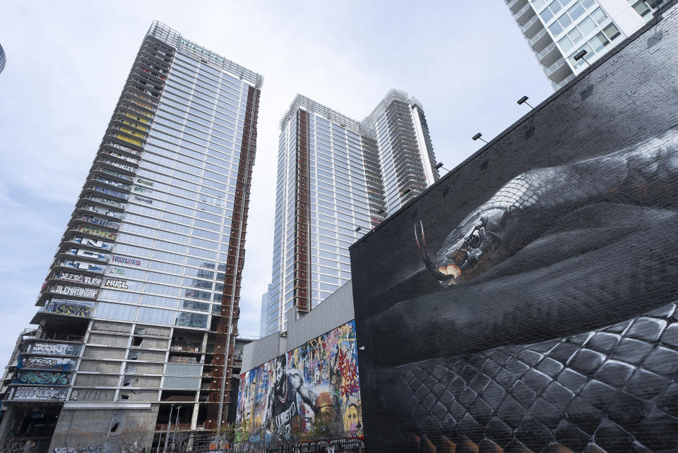 An unfinished complex of high-rise towers that have recently been vandalized with graffiti and used for dangerous social media stunts after the developer ran out of money is seen in downtown Los Angeles Friday, Feb. 16, 2024. The three towers have become an embarrassment in a high-profile area that includes Crypto.com Arena, home of major sports teams and events such as the Grammys, as well as the Los Angeles Convention Center and the L.A. Live dining and events complex. (AP Photo/Damian Dovarganes)