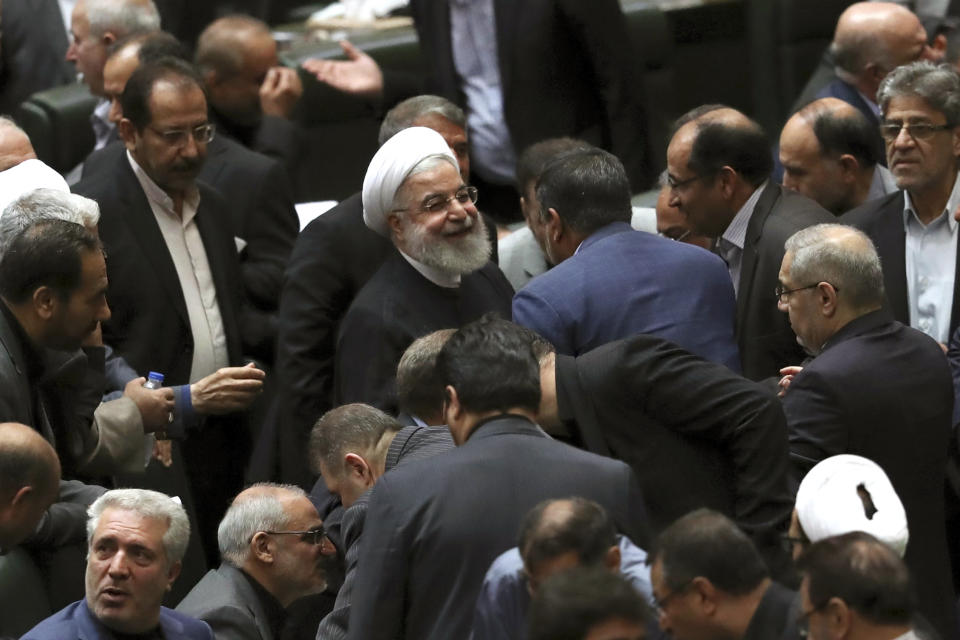 FILE - In this Sept. 3, 2019, file photo, Iranian President Hassan Rouhani, center, listens to a lawmaker after defending his proposed tourism and education ministers, in Tehran, Iran. Rouhani reiterated Tuesday, Sept. 24, that he would not consider meeting with President Donald Trump unless sanctions imposed against his country since 2018 were first lifted. (AP Photo/Vahid Salemi, File)