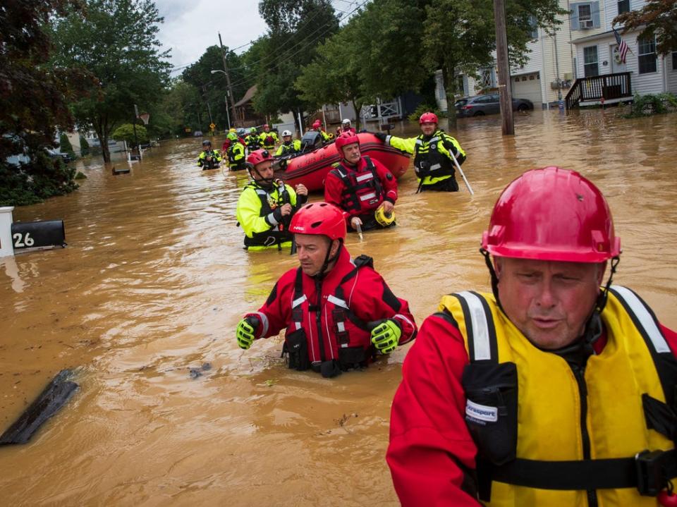 Members of the New Market Volunteer Fire Company perform a secondary search during an evacuation effort following a flash flood, as Tropical Storm Henri makes landfall, in Helmetta, New Jersey (AFP via Getty Images)