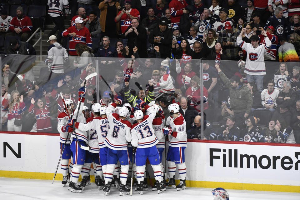 Montreal Canadiens players celebrate after Justin Barron's winning goal against the Winnipeg Jets in overtime of NHL hockey game action in Winnipeg, Manitoba, Monday, Dec. 18, 2023. (Fred Greenslade/The Canadian Press via AP)