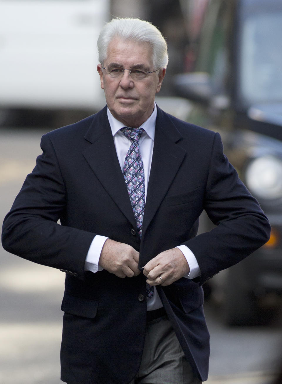 British public relations guru Max Clifford arrives at Southwark Crown Court in London for jury selection before his trial on charges of indecent assault, Wednesday, March 5, 2014. Clifford faces 11 counts of indecent assault on 7 alleged teenagers between 1966 and 1984. (AP Photo/Alastair Grant)