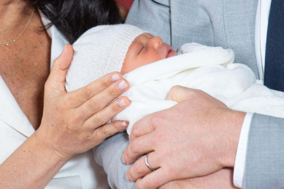 A first look at Baby Sussex, before his name was announced, in his father's arms two days after his birth [Photo: PA]