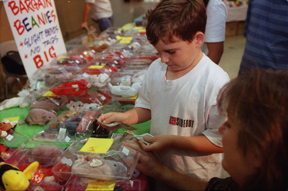 A boy sells beanie babies with his mother