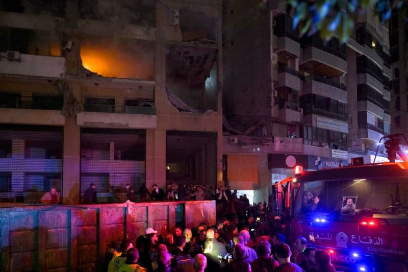 Lebanese firefighters gather around a building targeted in a blast, that resulted in killing Hamas deputy leader Saleh al-Arouri an six other people. The cause was initially unclear but reports quickly began to circulate suspecting that it could have been a targeted killing on behalf of Israel. Stringer/dpa