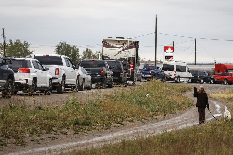 Los vehículos se alinean para cargar combustible en Fort Providence, Territorios del Noroeste, en la única carretera al sur de Yellowknife, el jueves 17 de agosto de 2023
