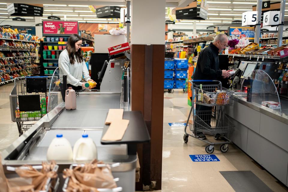 Olivia Shrewsbery, left, of Hilliard, uses the new conveyer belt self check out, at the Kroger store in Dublin, Ohio. Kroger is experimenting with a self-checkout technology where shoppers use a conveyor checkout.