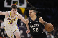 Orlando Magic guard Cole Anthony (50) dribbles past Los Angeles Lakers guard Austin Reaves (15) during the second half of an NBA basketball game Sunday, March 19, 2023, in Los Angeles. (AP Photo/Marcio Jose Sanchez)