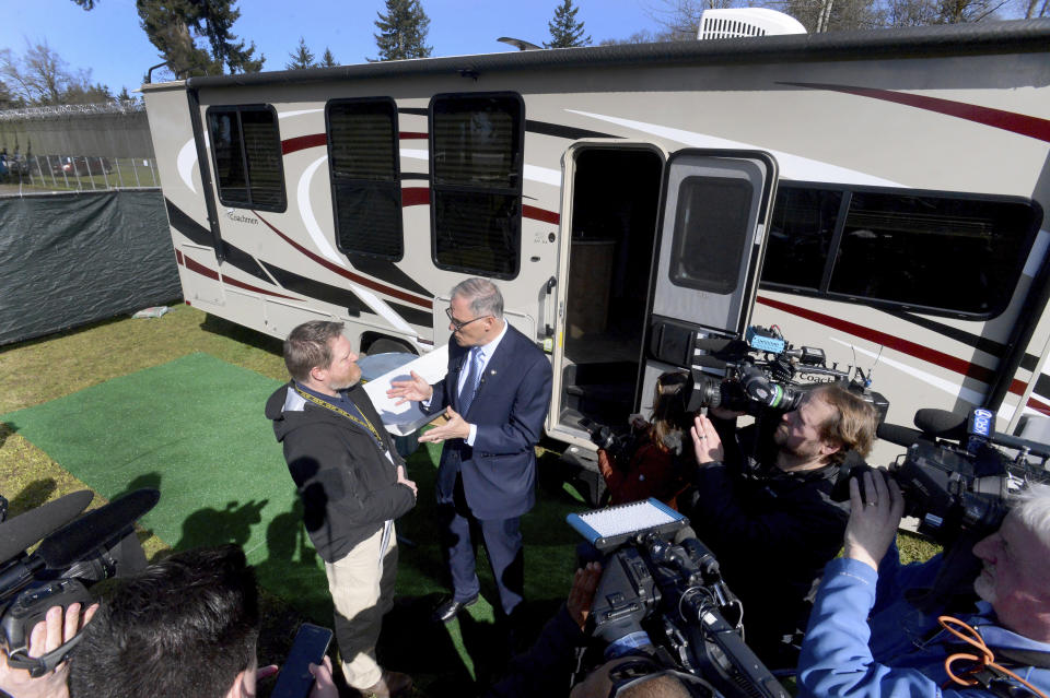 Washington Gov. Jay Inslee tours the group of RV's set-up for potential isolation and quarantine of COVID-19 patients in Grand Mound, Wash. on Wednesday, March 4, 2020 after earlier stops at the state Emergency Operations Centers at Camp Murray and the Dept. of Health's Tumwater location. He was joined by Nathan Weed, left, Dept. of Health incident commander who conducted the tour for Gov. Inslee. (Steve Bloom/The Olympian via AP)