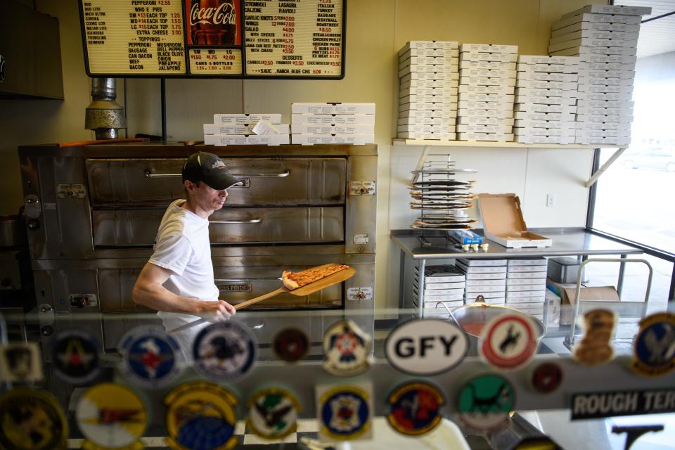 Manager Eric Grimes pulls a slice from the oven for a customer at Brooklyn Pizzeria on Wednesday, Feb. 13, 2019, in Spring Lake.