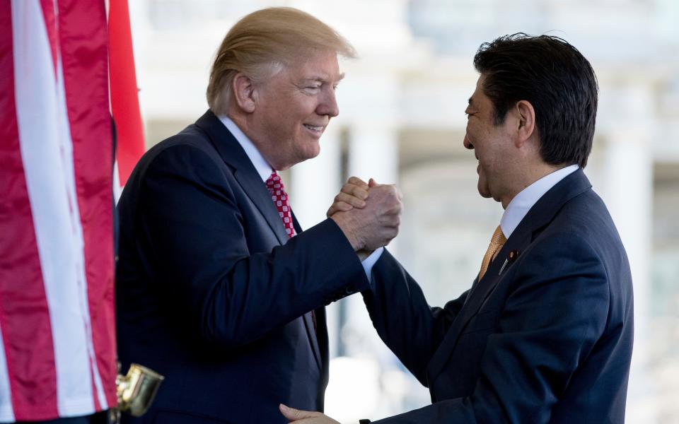 Mr Trump welcomes Mr Abe to the White House in February 2017 - Credit: AP Photo/Andrew Harnik