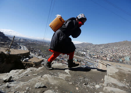 An Afghan girl carries water on her back as she climbs a hill in Kabul, Afghanistan February 20, 2017. Picture taken February 20, 2017. REUTERS/Omar Sobhani