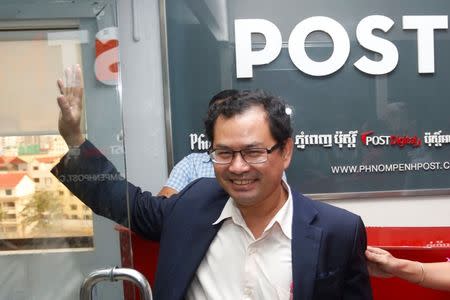 Editor-in-Chief Kay Kimsong waves as he walks out after being fired from the Phnom Penh Post newspaper in Phnom Penh, Cambodia May 7, 2018. REUTERS/Stringer