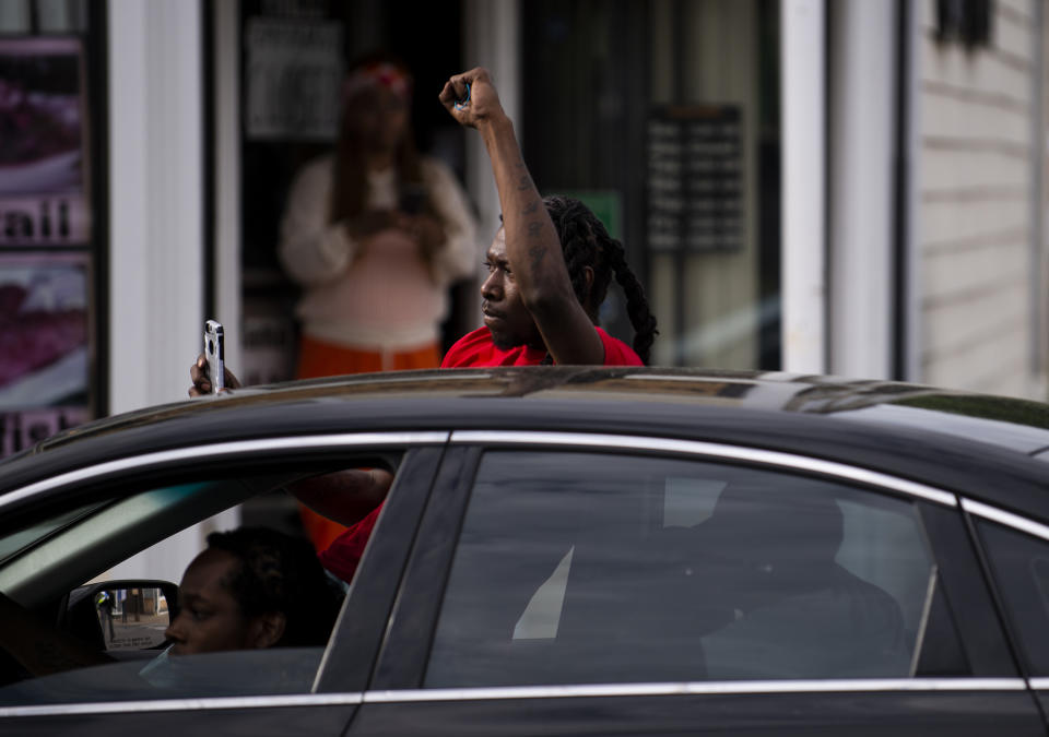 A man leans out of his car and with a raised fist as protesters march by decrying the killing of George Floyd in Minneapolis on May 26. | Stephen Maturen—Getty Images