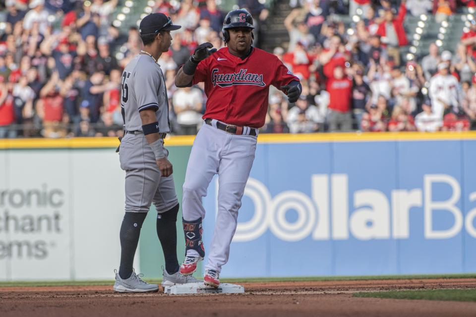 Cleveland Guardians' Jose Ramirez celebrates at second base after hitting an RBI double off Gerrit Cole as Gleyber Torres stands by during the first inning of a baseball game in Cleveland, Tuesday April 11, 2023. (AP Photo/Phil Long)