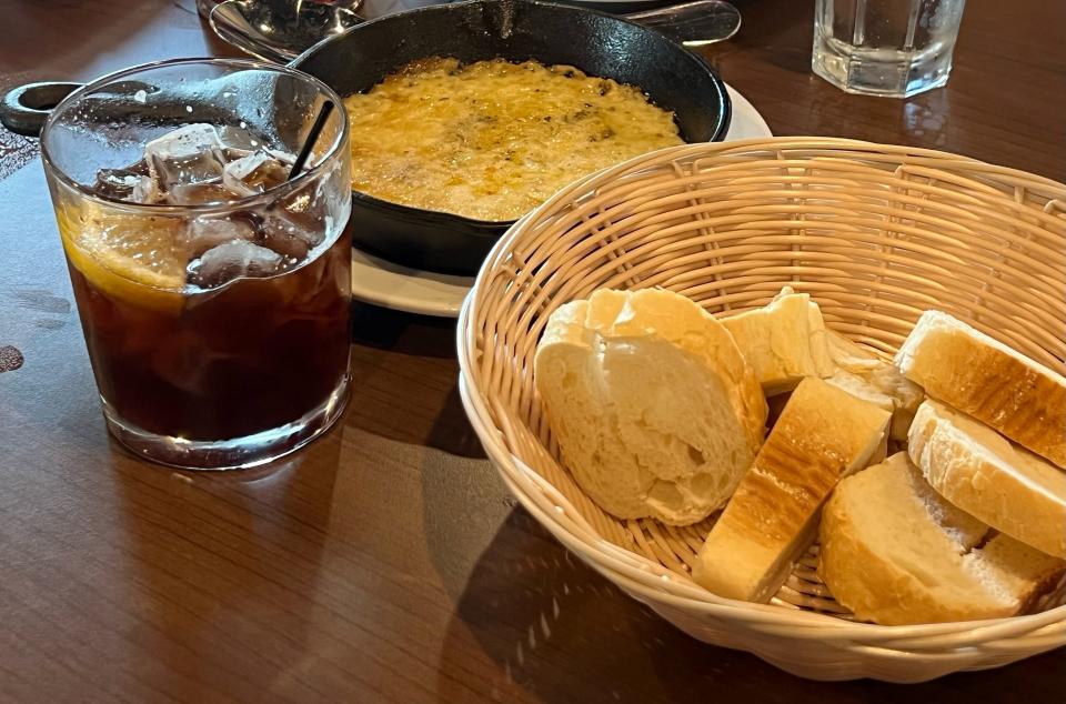 Pictured is provoleta cheese from El Gaucho, as well as the pasubio and Coca-Cola cocktail. Both are Argentinian fixtures.