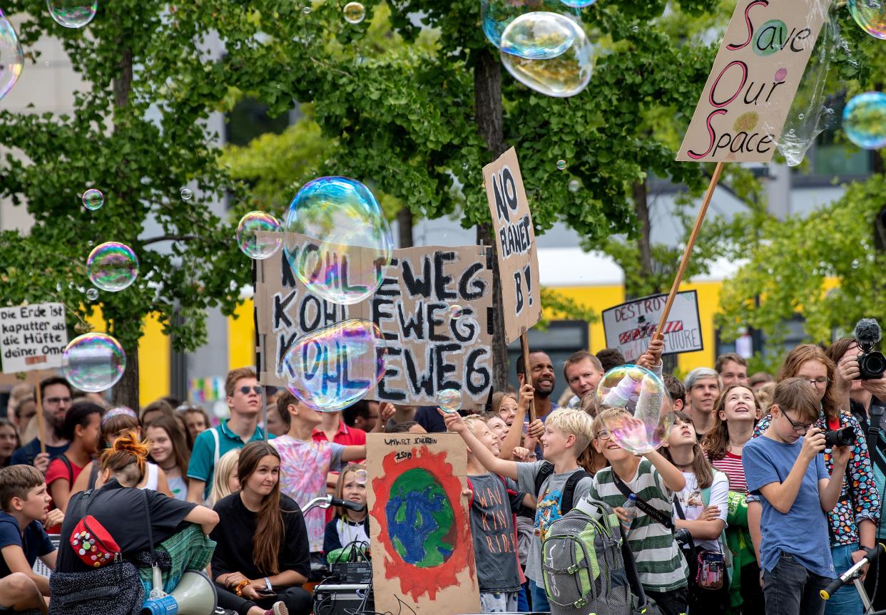 Young demonstrators hold up their posters and make soap bubbles as they take part in a "Fridays for Future" protest for climate action on August 16, 2019 in Berlin. (Photo by Monika Skolimowska / dpa / AFP) / Germany OUT        (Photo credit should read MONIKA SKOLIMOWSKA/AFP/Getty Images)